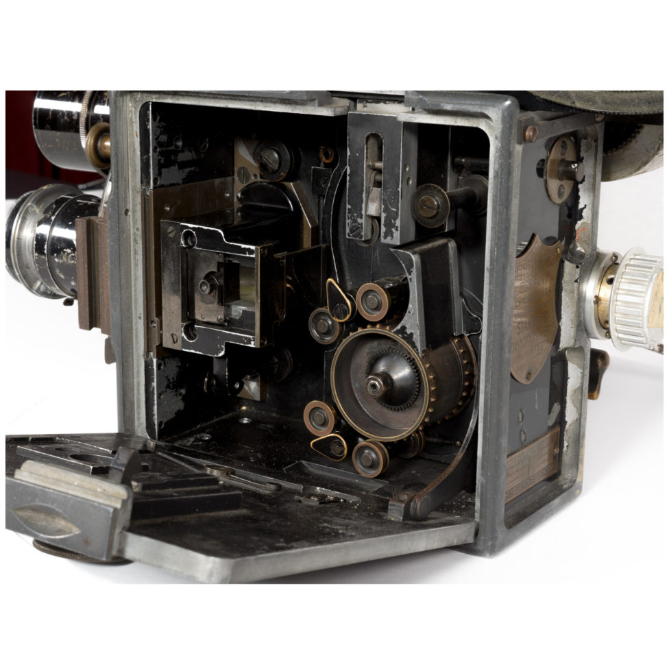 The body of the Bell & Howell is open, exposing the metal drive mechanism.