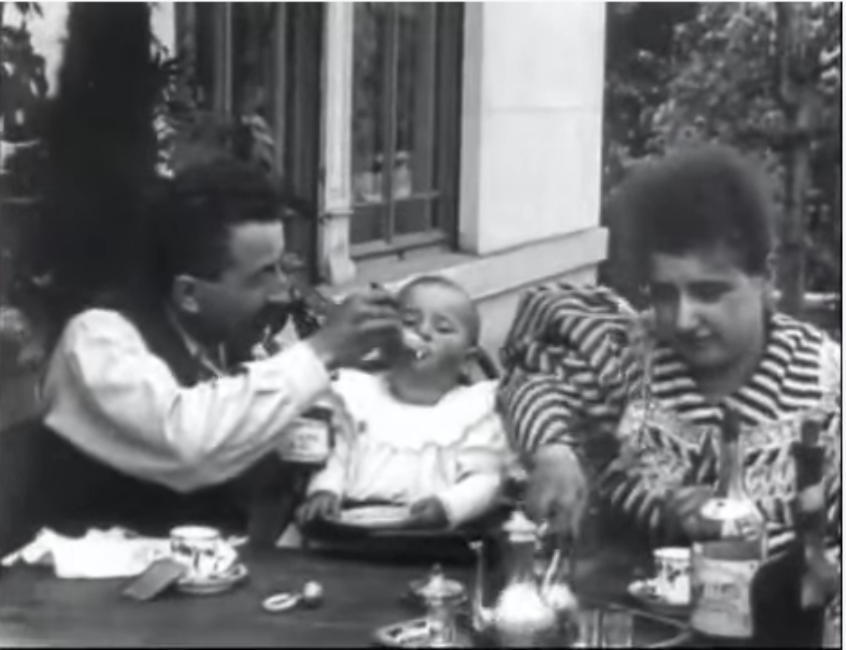 In the garden in front of their villa in Lyon, Auguste Lumière (left), his daughter Andrée (middle) and his wife Marguerite (right) eat and drink. 