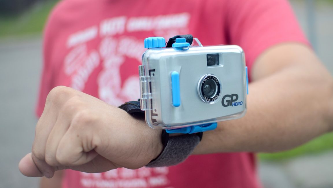 Close-up of a man’s arm with a small camera strapped to the wrist.